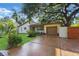 Charming home with a lush front lawn, driveway, shade trees, and wooden privacy fence at 4926 Camellia S Way, St Petersburg, FL 33705