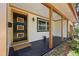 Covered front porch featuring decorative door, black painted concrete and manicured garden at 4926 Camellia S Way, St Petersburg, FL 33705