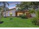 Charming single-story home with a lush green lawn, mature trees, and a well-maintained landscape at 4926 Camellia S Way, St Petersburg, FL 33705