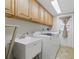 Functional laundry room featuring a sink, a washer, a dryer, and lots of storage cabinets for convenience at 4926 Camellia S Way, St Petersburg, FL 33705
