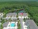An aerial view of townhomes, a community pool, pond, and forest at 5509 Cumberland Star Ct, Lutz, FL 33558