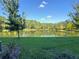 Picturesque backyard view of a serene lake surrounded by lush greenery and a clear blue sky, creating a tranquil setting at 5509 Cumberland Star Ct, Lutz, FL 33558
