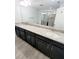 Bathroom featuring a dual sink vanity with granite countertops and a large mirror reflecting the shower at 5509 Cumberland Star Ct, Lutz, FL 33558