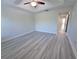 Bright bedroom with sleek gray floors, ceiling fan, and access to a large closet for ample storage at 5509 Cumberland Star Ct, Lutz, FL 33558