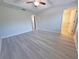 Bright bedroom with sleek gray floors, ceiling fan, and access to a large closet for ample storage at 5509 Cumberland Star Ct, Lutz, FL 33558