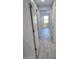 Hallway with light gray wood-look floors, white doors, and natural light at 5509 Cumberland Star Ct, Lutz, FL 33558