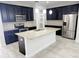 Modern kitchen with black cabinets, stainless steel appliances, and a large island at 5509 Cumberland Star Ct, Lutz, FL 33558