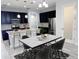 Modern kitchen with black cabinets, stainless steel appliances, island, and an adjacent dining area with a white marble table at 5509 Cumberland Star Ct, Lutz, FL 33558