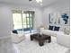 Bright living room with sliding doors leading to outdoor view, featuring neutral decor and comfortable white seating at 5509 Cumberland Star Ct, Lutz, FL 33558