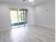 Minimalist living room featuring a sliding door to the back, light tile flooring, and ample natural light at 5509 Cumberland Star Ct, Lutz, FL 33558