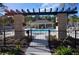 Community pool area with a pergola covered walkway and lounging chairs with a clubhouse nearby at 5509 Cumberland Star Ct, Lutz, FL 33558