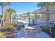 Community pool and lounging area with shade structures and tables surrounded by palm trees and lush landscaping at 5509 Cumberland Star Ct, Lutz, FL 33558