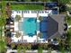 Aerial view of sparkling community pool area with ample seating, palm trees and a modern clubhouse at 5509 Cumberland Star Ct, Lutz, FL 33558