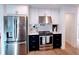 Modern kitchen featuring stainless steel appliances, white cabinets, and dark countertops at 6337 Cocoa Ln, Apollo Beach, FL 33572