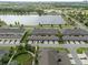 Aerial view of homes showcases garage parking, green spaces, landscaping, and street parking near the lake at 6337 Shore Vista Pl, Apollo Beach, FL 33572