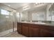 Bathroom featuring double sinks, granite countertop, and glass door shower at 6337 Shore Vista Pl, Apollo Beach, FL 33572
