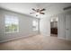 Bright bedroom with neutral walls and carpet flooring with ceiling fan and access to bathroom at 6337 Shore Vista Pl, Apollo Beach, FL 33572