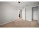 Bedroom with neutral carpet, ceiling fan, and open door to bathroom at 6337 Shore Vista Pl, Apollo Beach, FL 33572