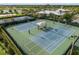 Aerial shot of well-kept tennis courts with shade structures for a comfortable playing experience at 6337 Shore Vista Pl, Apollo Beach, FL 33572
