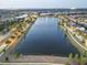 Expansive aerial view of a peaceful lake community with lush landscaping and evening illumination at 7209 Meeting House Ln, Apollo Beach, FL 33572