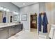 Spacious bathroom featuring double vanity, granite counters, and access to walk-in closet at 7209 Meeting House Ln, Apollo Beach, FL 33572