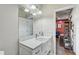 Bathroom featuring double sinks with a marble countertop, modern fixtures, and access to a home office at 7209 Meeting House Ln, Apollo Beach, FL 33572