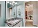 Light-filled bathroom with granite counters, tile flooring and a large mirror at 7209 Meeting House Ln, Apollo Beach, FL 33572