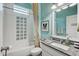 Colorful bathroom with patterned shower and granite counters and white cabinets at 7209 Meeting House Ln, Apollo Beach, FL 33572