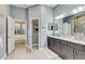 Bathroom with double vanity, granite counters, grey cabinets and tile flooring at 7209 Meeting House Ln, Apollo Beach, FL 33572