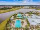 Aerial view of the luxurious community pool, with a lake and nearby roadways at 7209 Meeting House Ln, Apollo Beach, FL 33572