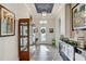 Elegant foyer featuring a decorative display case and console table, leading to a bright interior at 7209 Meeting House Ln, Apollo Beach, FL 33572