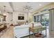 A bright and airy living room features tile floors, a modern ceiling fan, and a sliding glass door at 7209 Meeting House Ln, Apollo Beach, FL 33572