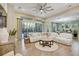 Bright living room featuring a white sectional sofa, decorative curtains, and sliding glass doors at 7209 Meeting House Ln, Apollo Beach, FL 33572