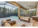 The covered lanai is furnished with couches and chairs, overlooking a well-maintained pool and landscaping at 7209 Meeting House Ln, Apollo Beach, FL 33572