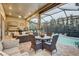An expansive covered patio with a dining area, grill, and outdoor seating, overlooking a serene pool and greenery at 7209 Meeting House Ln, Apollo Beach, FL 33572
