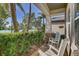 Cozy front porch featuring rocking chairs and views of lush landscaping and serene waterfront at 7209 Meeting House Ln, Apollo Beach, FL 33572
