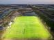 Aerial view of lit sports fields for community use, surrounded by neighborhood homes and roadways at dusk at 7209 Meeting House Ln, Apollo Beach, FL 33572