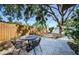 The backyard has a stone paver patio, mature trees, string lights, and a privacy fence at 7241 56Th N Ave, St Petersburg, FL 33709