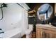 This bathroom has an oval mirror, wooden shelves, and a shower-tub combo at 7241 56Th N Ave, St Petersburg, FL 33709