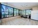 The bright Florida room has tiled flooring, picnic table, folding chairs, and a fridge at 7241 56Th N Ave, St Petersburg, FL 33709