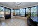 The tiled Florida room features lots of windows, a picnic table, and a ceiling fan at 7241 56Th N Ave, St Petersburg, FL 33709