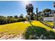 Sprawling backyard with green grass, privacy fence, mature trees, and a cozy fire pit area for outdoor enjoyment at 754 Seminole Blvd, Tarpon Springs, FL 34689