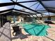 Screened-in pool with an irregular shape, featuring brick pavers, lounge chairs, and an open view to the backyard at 754 Seminole Blvd, Tarpon Springs, FL 34689