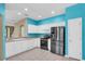 Well-lit kitchen with white cabinets, stainless steel appliances, and bright blue walls at 7826 66Th N Way, Pinellas Park, FL 33781
