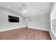Inviting living room with sleek hardwood floors, ceiling fan, and large TV for relaxing evenings at 7826 66Th N Way, Pinellas Park, FL 33781