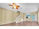 Living room featuring wood floors, stairs, a ceiling fan, and views into kitchen area at 7826 66Th N Way, Pinellas Park, FL 33781