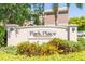 Park Place Townhomes community sign surrounded by lush landscaping and a glimpse of a two-story unit in the background at 7826 66Th N Way, Pinellas Park, FL 33781