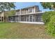 Exterior view of a house with a screened-in patio and a spacious green lawn at 8719 Lake Place Ln, Tampa, FL 33634
