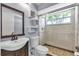 Updated bathroom with sleek vanity, frameless glass shower, and tiled shower at 8719 Lake Place Ln, Tampa, FL 33634