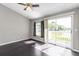 Cozy bedroom with wood floors and sliding door to outside balcony at 8719 Lake Place Ln, Tampa, FL 33634